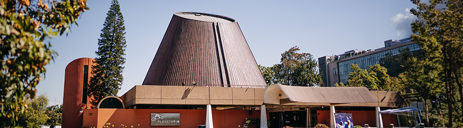 Frontis del Planetario USACH rodeado de árboles