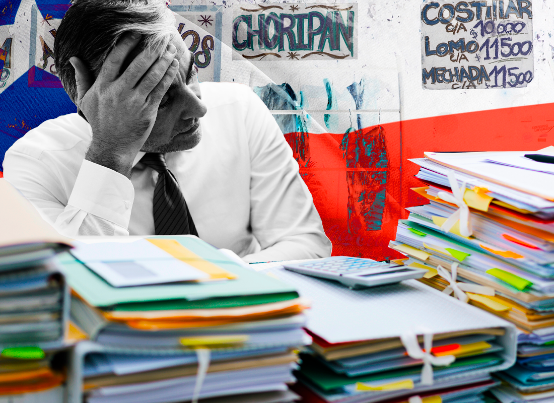 Persona agobiada por el trabajo pendiente sobre su escritorio