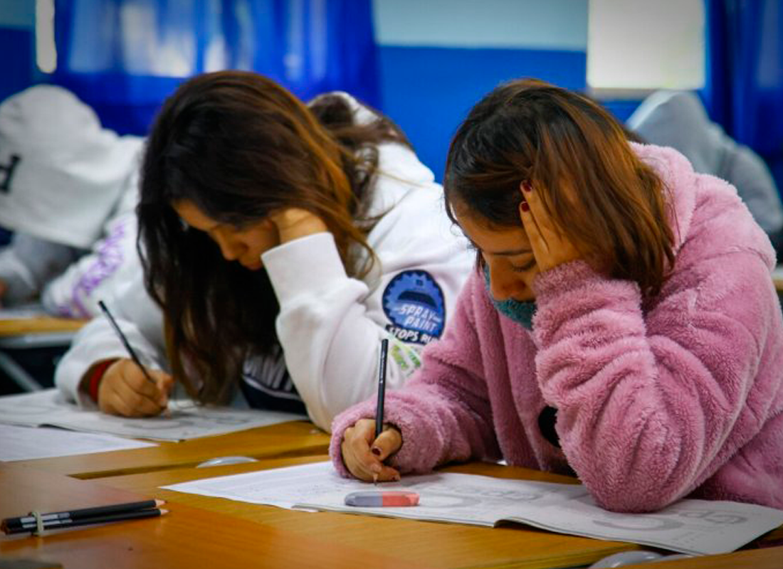 Estudiantes anotando en su cuaderno.