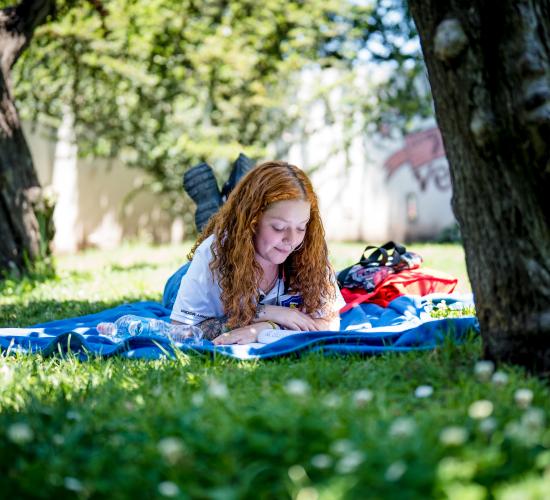 Estudiante acostada en el pasto