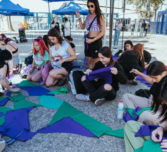 se muestra un grupo de mujeres en el campus preparándo las actividades a realizar en distintos sectores del Campus Universitario