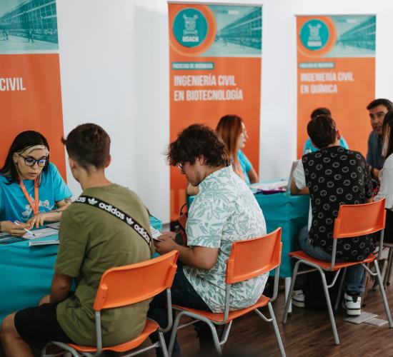 Asistentes visitando puesto informativos sobre las distintas carreras que imparte la universidad