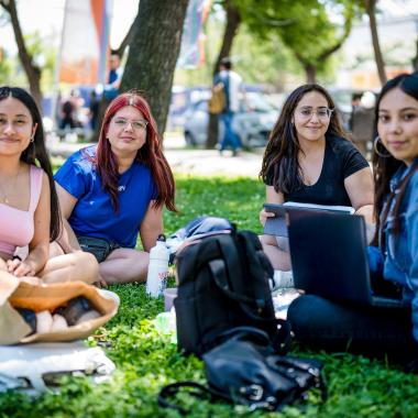 Estudiantes sentados en el pasto