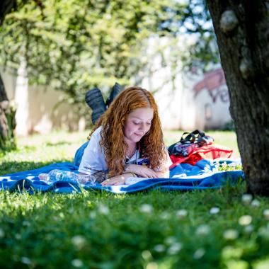 Estudiante acostada en el pasto