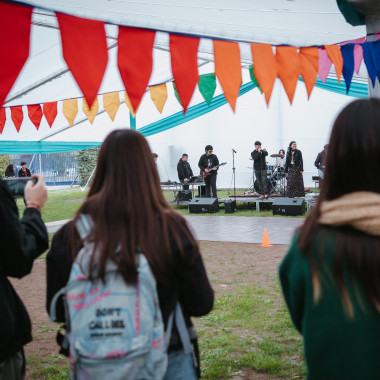 Estudiantes viendo como tocan musica en el escenario