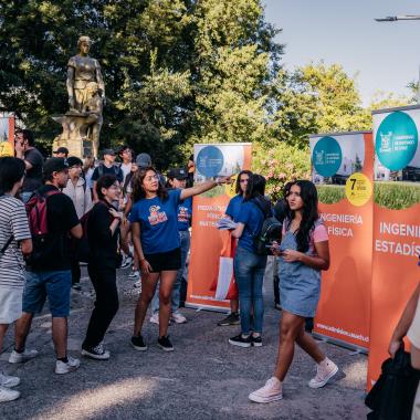 Grupo de estudiantes en el campus, se ve como ven el campus y una recibe indicaciones