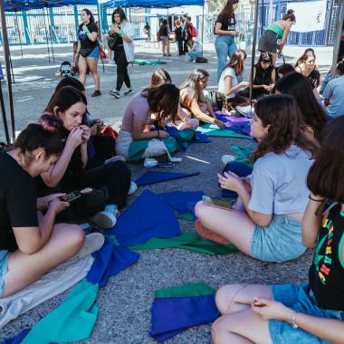 se muestra un grupo de mujeres en el campus preparándo las actividades a realizar en distintos sectores del Campus Universitario