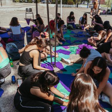 se muestra un grupo de mujeres en el campus preparándo las actividades a realizar en distintos sectores del Campus Universitario