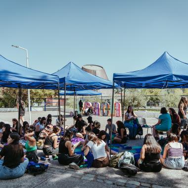 se muestra un grupo de mujeres en el campus preparándo las actividades a realizar en distintos sectores del Campus Universitario