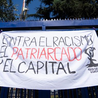 Lienzo que tiene escrito "contra el racismo, el patriarcado y el capital"