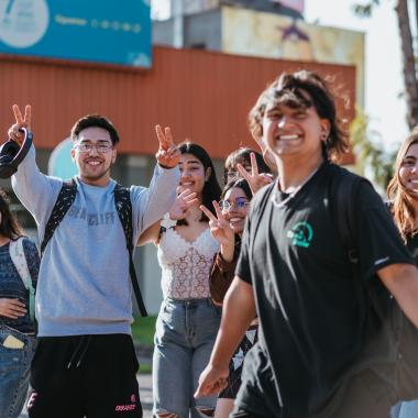 Se muestra un grupo de estudiantes saludando a la camara