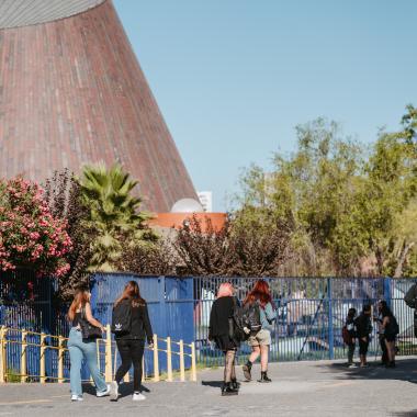 en esta imagen se logra apreciar a estudiantes recorriendo el campus y al lado izquierdo el planetario de la universidad