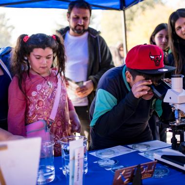 Grupos de escolares de enseñanza visitando stand donde se mostraban distintos tipos de experimentos científicos