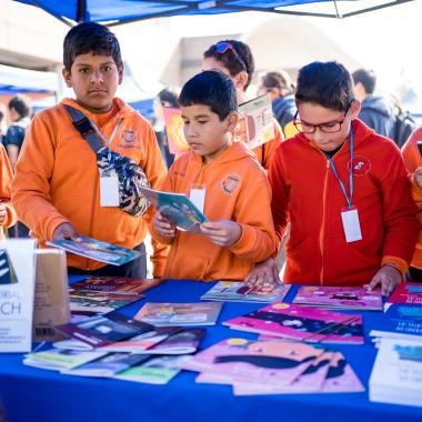 Visitantes al lanzamiento de la revista viendo los distintos números de la revista