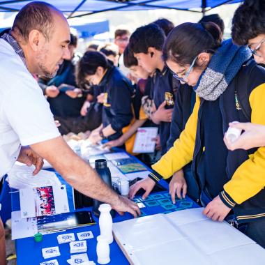 Grupos de escolares de enseñanza visitando stand donde se mostraban distintos tipos de experimentos científicos