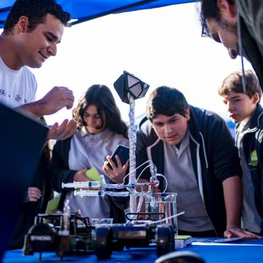 Grupos de escolares de enseñanza visitando stand donde se mostraban distintos tipos de experimentos científicos