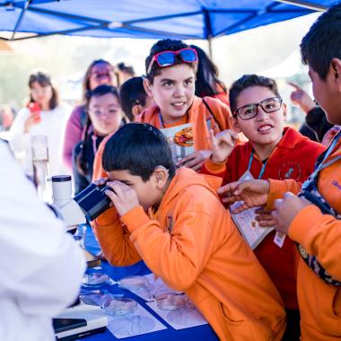 Grupos de escolares de enseñanza visitando stand donde se mostraban distintos tipos de experimentos científicos