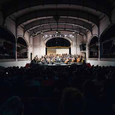 Publico mirando el escenario donde se presenta el concierto 