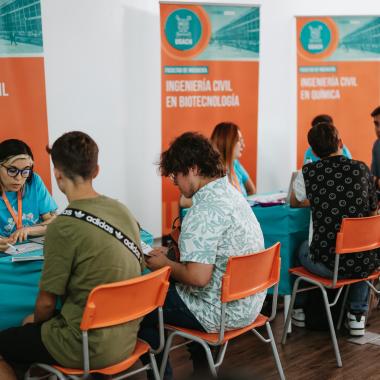 Asistentes visitando puesto informativos sobre las distintas carreras que imparte la universidad