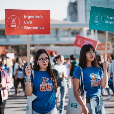 Estudiantes con letreros para que los nuevos puedan guiarse 