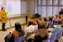 Profesora al frente de un grupo de estudiantes en una sala de clases 