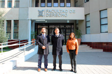 Dos hombres (a la izquierda) y una mujer (a la derecha) posan frente al edificio de la Facultad de Derecho