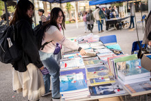 Imagen muestra a dos mujeres escogiendo libros de editorial Usach