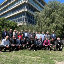 Académicos de la Facultad de Arquitectura Usach en encuentro internacional en Argentina. Posan sobre un verde pasto y un edificio de la Universidad.