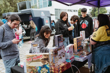 Estudiantes Usach frente a stand de juegos de mesa