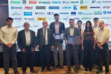 Investigadores del de E2Tech reciben premio. En el fondo, una pantalla con los auspiciadores del certamen.