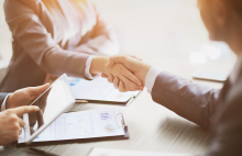 Dos personas se dan la mano.