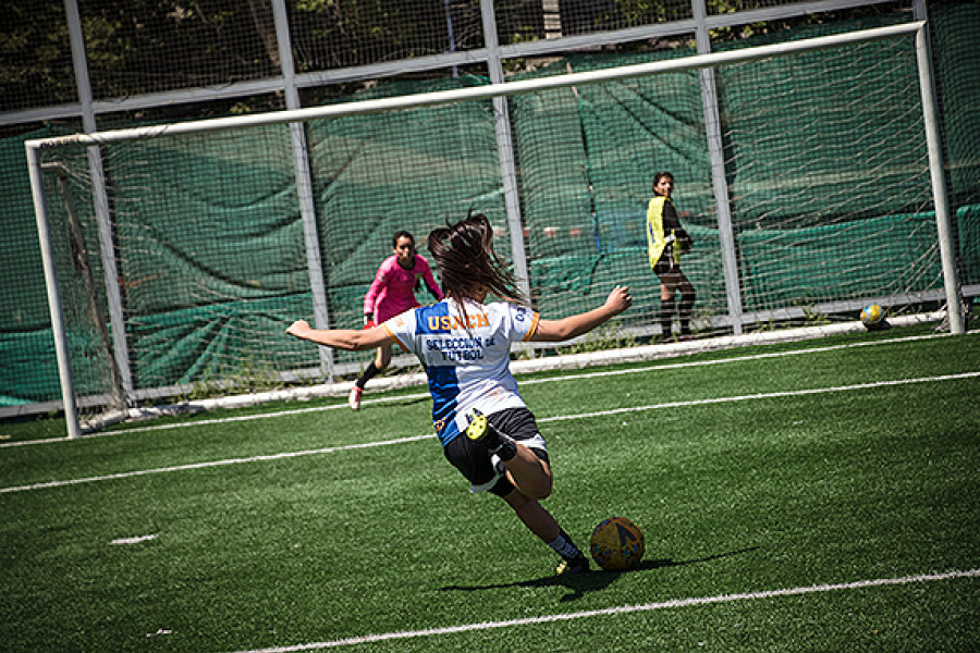 Jugadora de fútbol patea balón al arco 