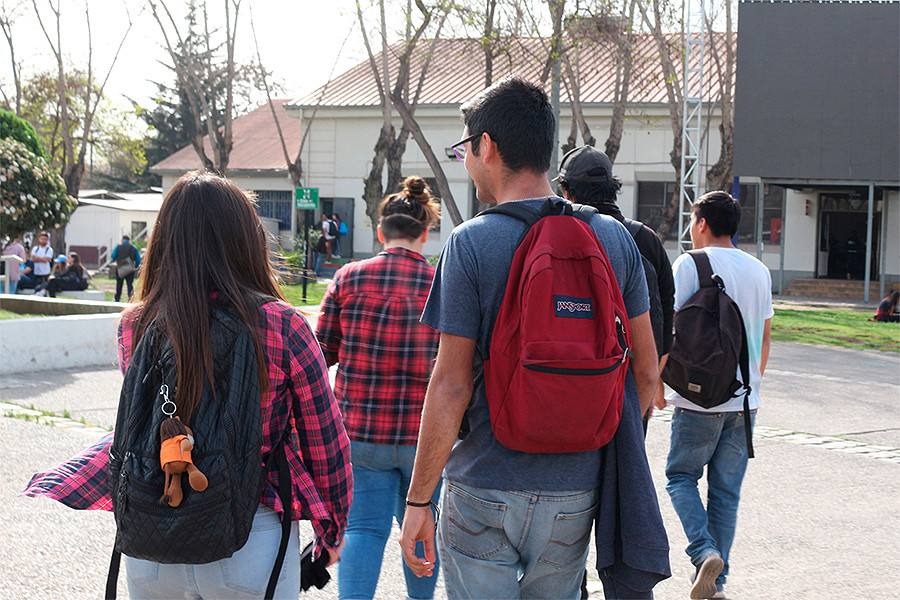 Jóvenes de espalda entrando a la Universidad