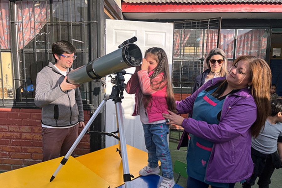 Niña observa a través de un telescopio 