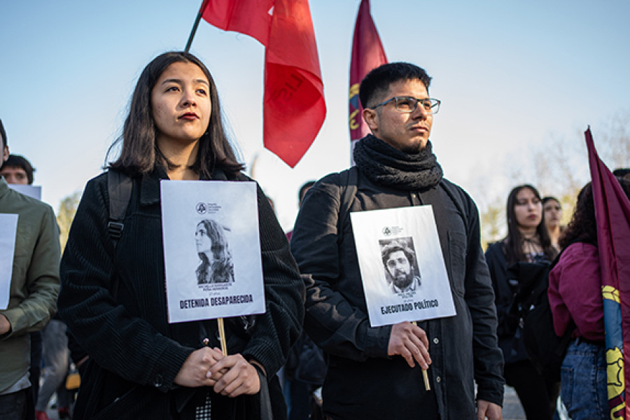 Dos jóvenes con carteles de detenidos desaparecidos 