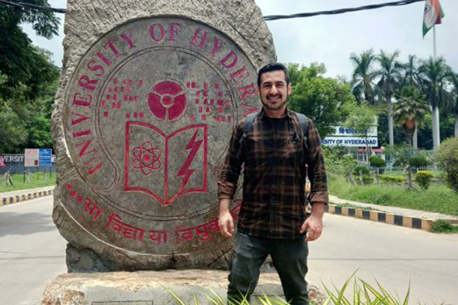 Estudiante Usach posa frente a escudo de universidad india