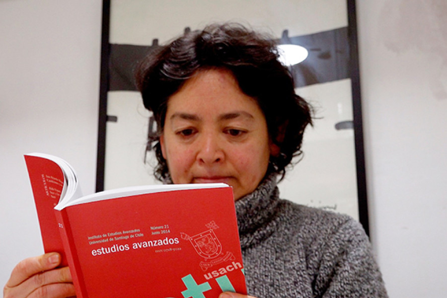 Gloria Baigorrotegui, directora de la revista, leyendo una versión impresa de la Revista Estudios Avanzados 