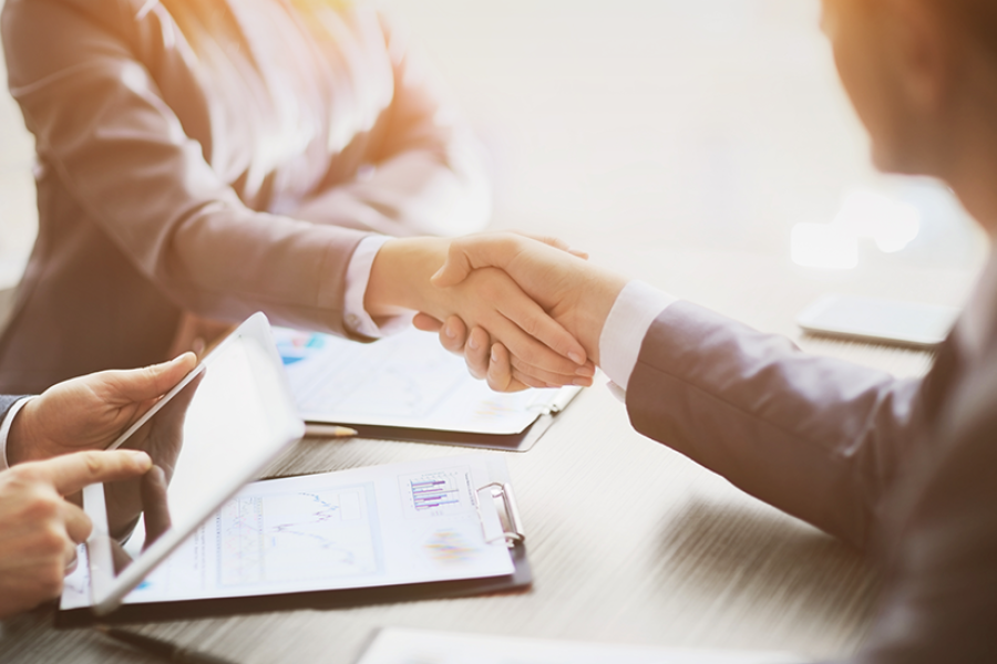 Dos personas se dan la mano.