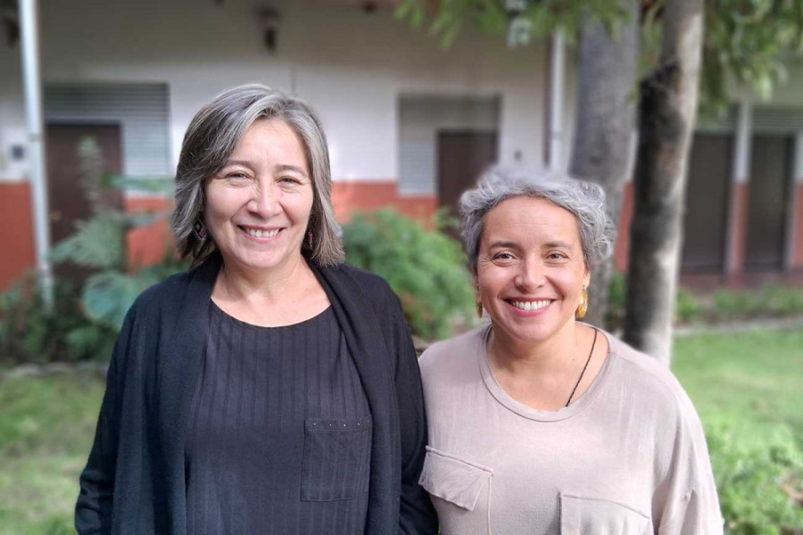Dos mujeres posan frente a la cámara 