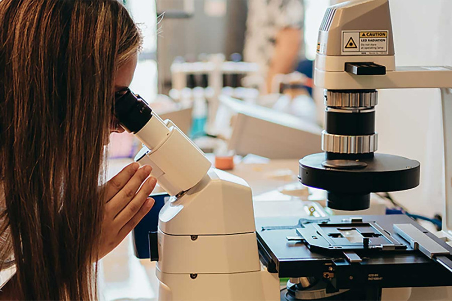 Investigadora en laboratorio trabaja con microscopio