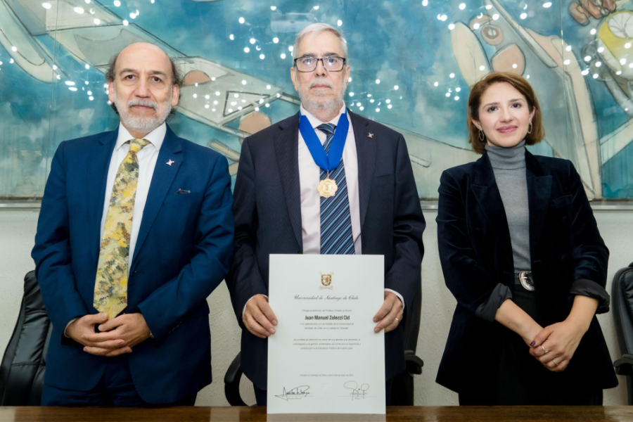 Aparecen en la fotografía el Rector Usach, Dr. Rodrigo Vidal Rojas, el nuevo Profesor Emérito de la Universidad, Juan Manuel Zolezzi y la Secretaria General de la Universidad, Sandra Barrera de Proença. De fondo el cuadro  Vivir enfrentando las flecha, del pintor surrealista Roberto Matta
