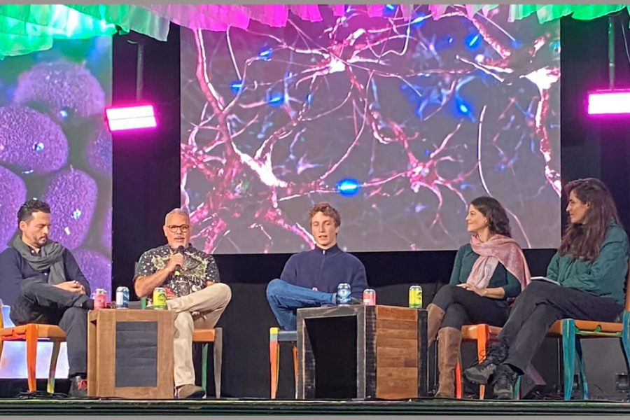 El Dr. Fernando Ortiz, director VIME de la Facultad de Química y Biología participó en los paneles de Políticas Públicas, Divulgación Científica y Salud Mental representando a la Universidad de Santiago en el Festival Reino Fungi.  En la fotografía aparecen sentados junto a él 2 expertas y 2 expertos. En el fondo, una pantalla con imágenes del proceso celular.