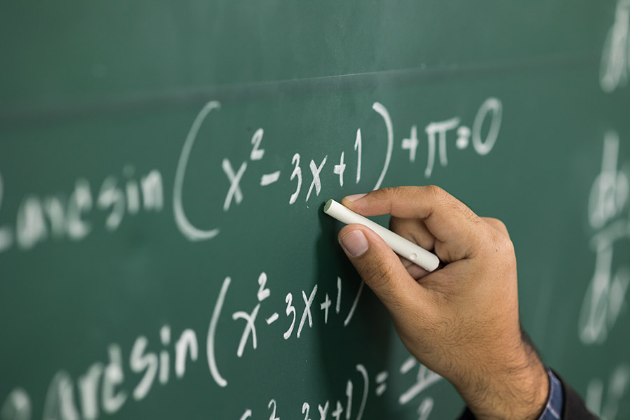 Mano escribiendo en una pizarra