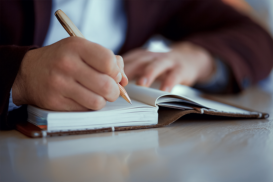 Manos escribiendo en una libreta
