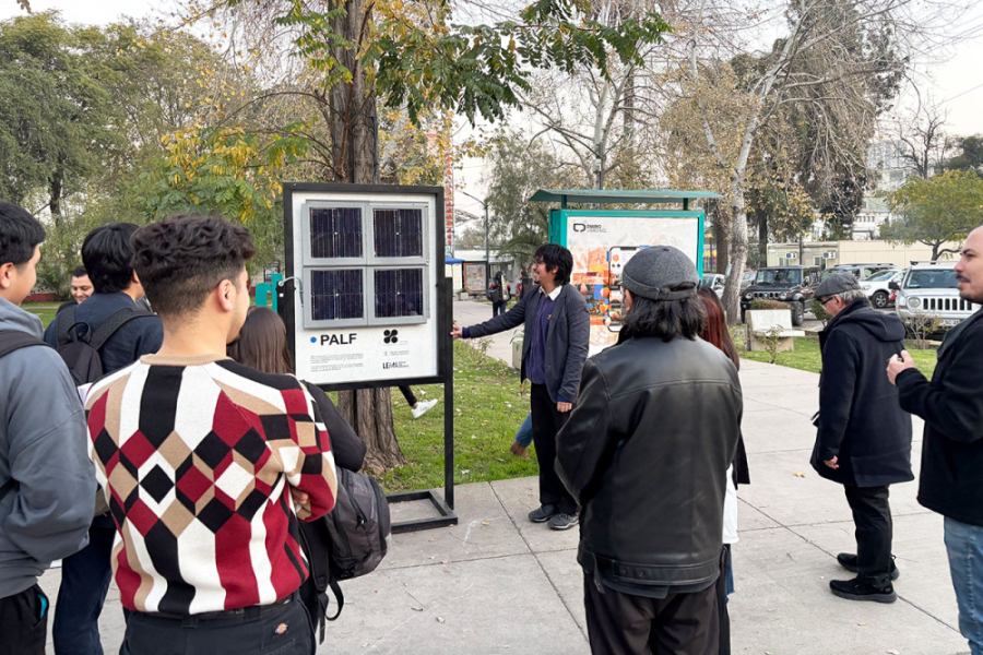 Guía de la muestra entrega información a los asistentes a la actividad. La imagen muestra el pasillo de acceso a la Facultad de Arquitectura y Ambiente Construido y un módulo informativo.