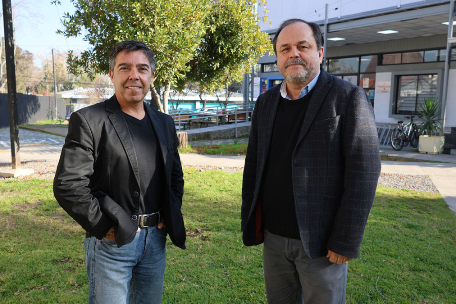 Dr. Tito Pizarro y el profesor Fernando Concha, de la Escuela de Ciencias de la Actividad Física, (Eciades) de la Facultad de Ciencias Médicas Usach, posan en el exterior de la fachada de la Facultad. En el fondo se aprecia el frontis de a Escuela de Enfermería.
