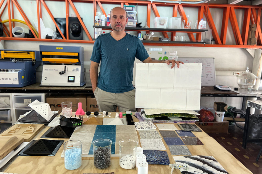 Dr. Alexandre Carbonnel, investigador del laboratorio Lemaa de la Facultad de Arquitectura y Ambiente Construido, posa en su laboratorio de trabajo. Lleva una polera en tonos azul y un pantalon gris