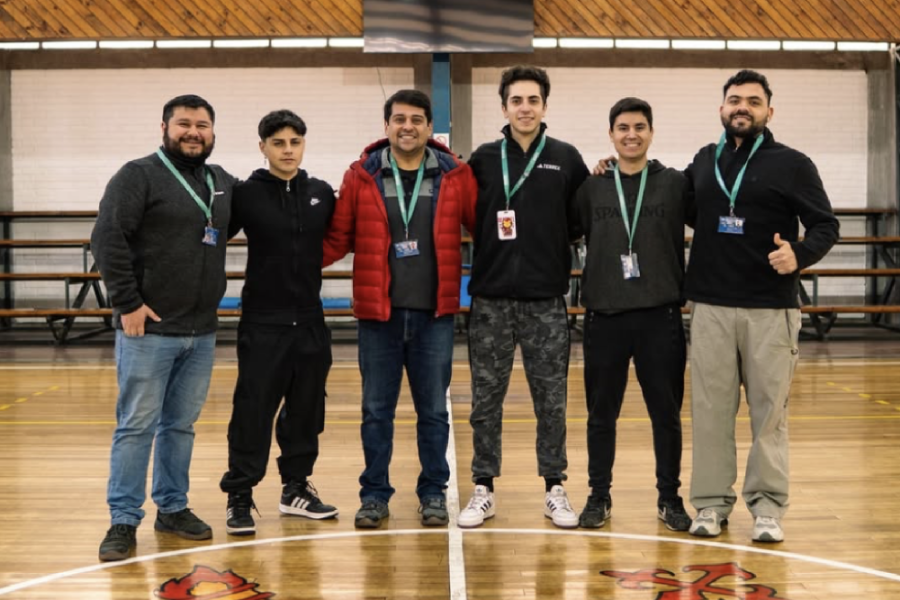 En la fotografía aparecen estudiantes seleccionados de deportes y parte del cuerpo académico de la carrera de Kinesiología. De fondo, las gradas del gimnasio Usach.