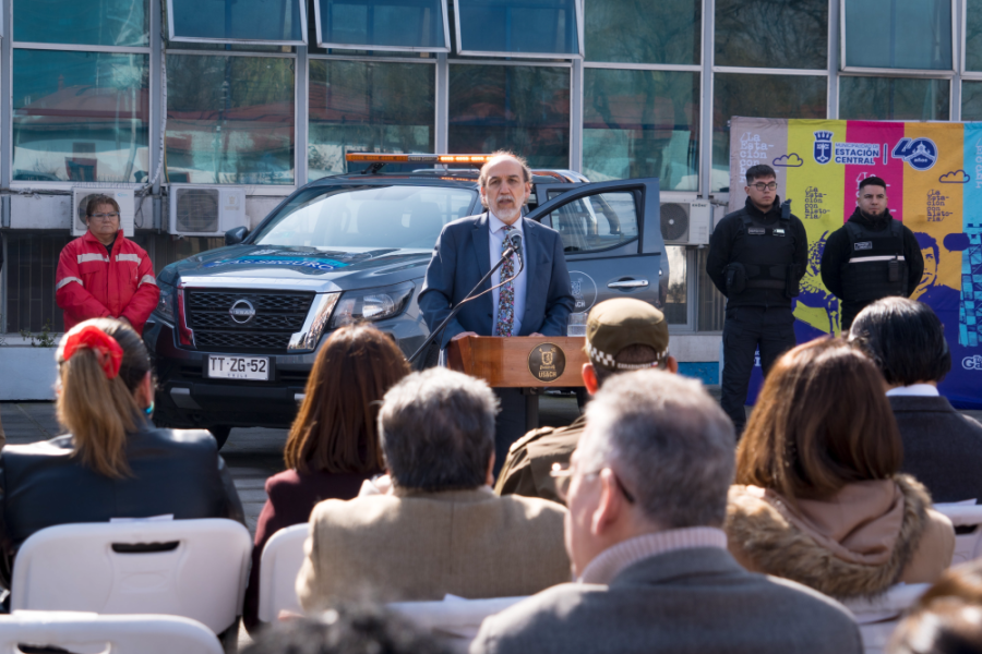Rector se dirige ala audiencia en las afueras de la Casa Central. En el plano de fondo se observa la camioneta de seguridad donada por nuestra universidad