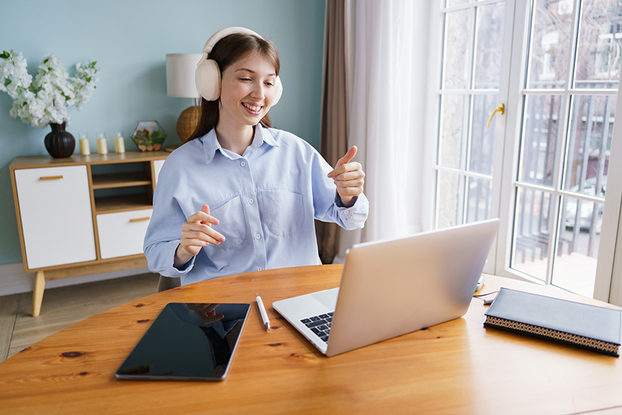 Student in a welcoming environment with headphones interacting in front of their computer